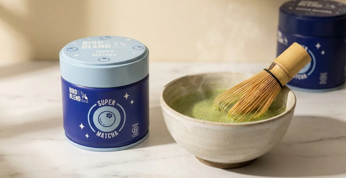 Bird and Blend matcha powder in a ceremonial bowl with bamboo whisk on a neutral background