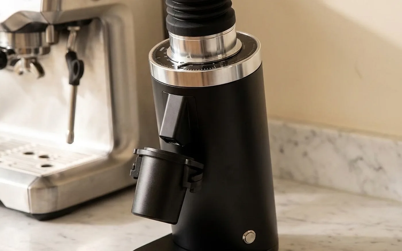 MiiCoffee DF64 single-dose coffee grinder on white marble with espresso machine background