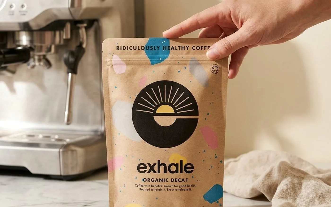 Exhale Coffee Organic Decaf bag with espresso machine on white marble