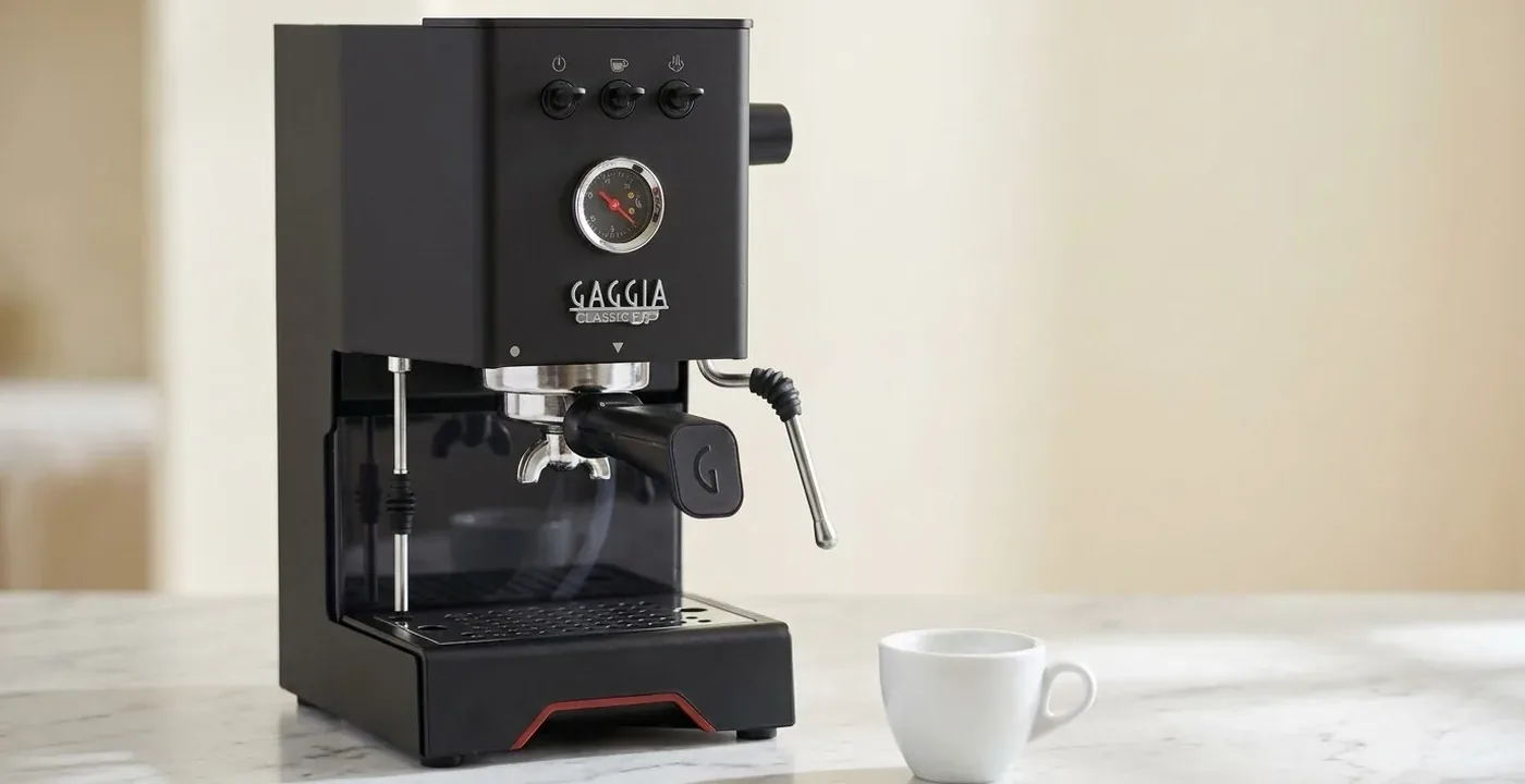 Gaggia Classic Up espresso machine on a white marble kitchen counter with a small white espresso cup
