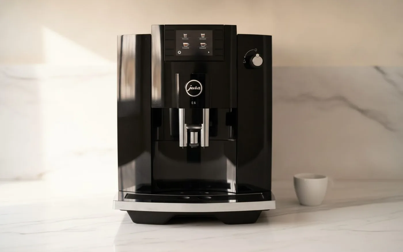 Jura E6 Piano Black automatic espresso machine on white marble countertop