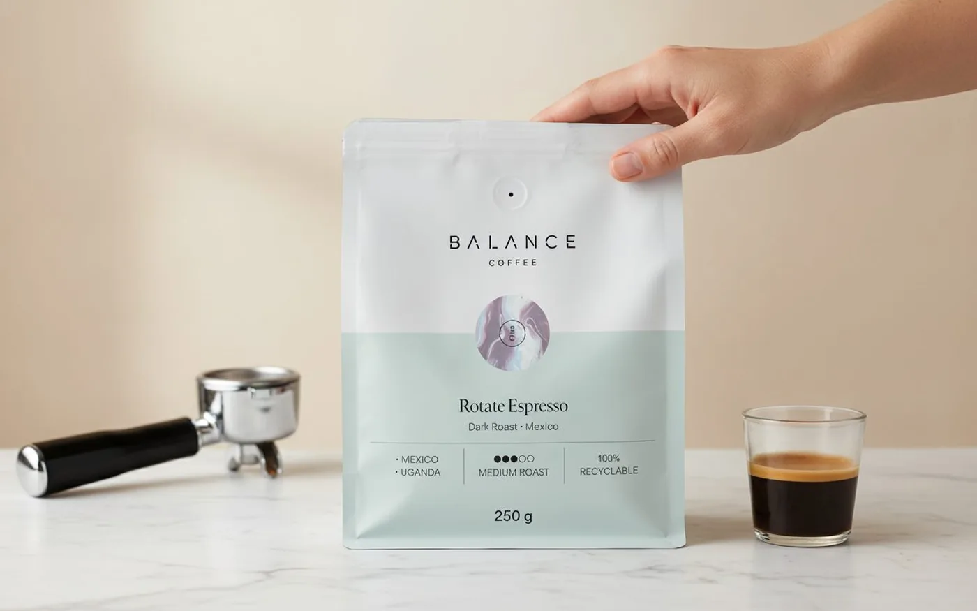 Balance Coffee whole-bean espresso bag on white marble beside the La Marzocco Linea Mini portafilter and a glass of espresso