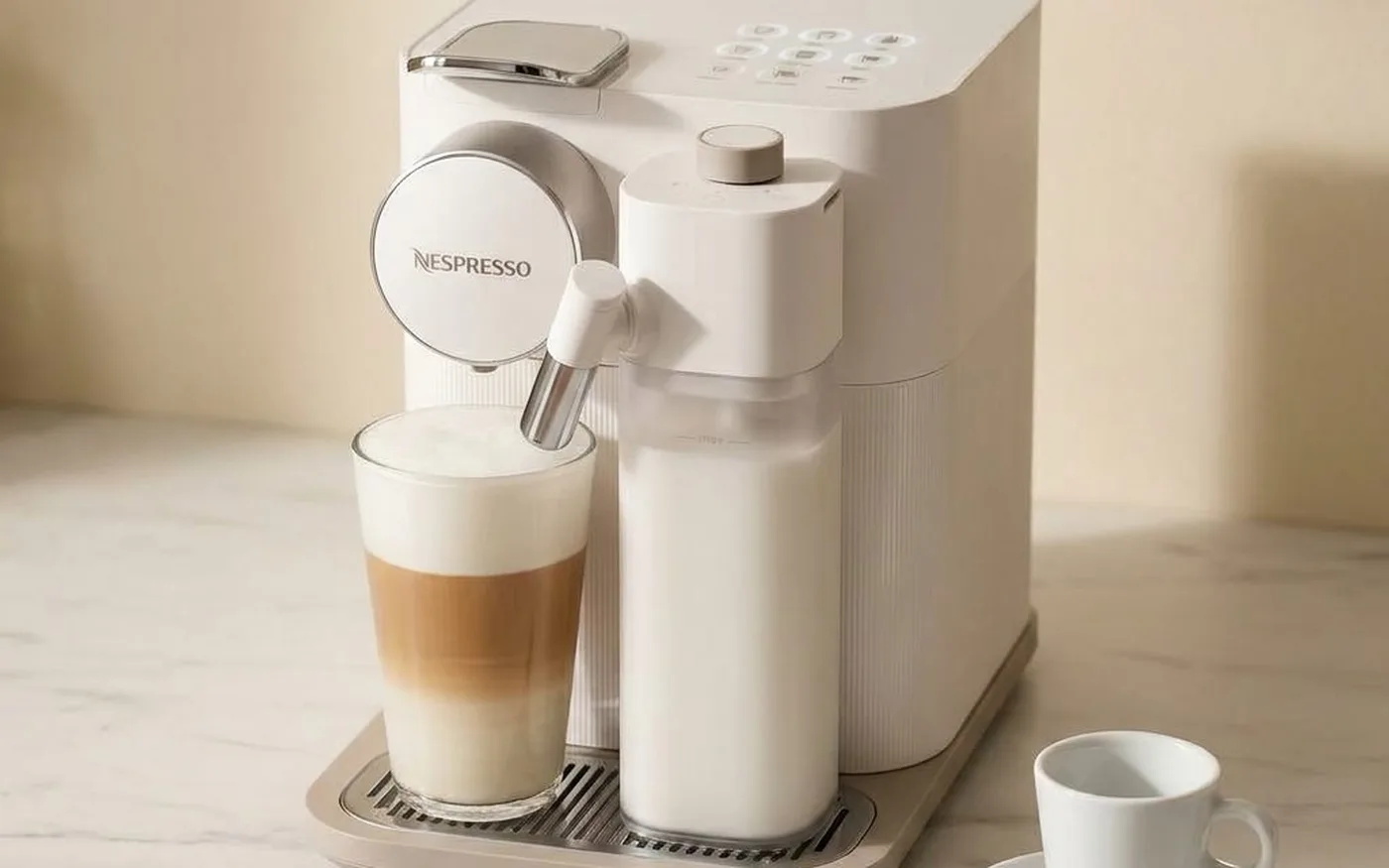 Nespresso Gran Lattissima EN640 white coffee machine on marble countertop with espresso cup