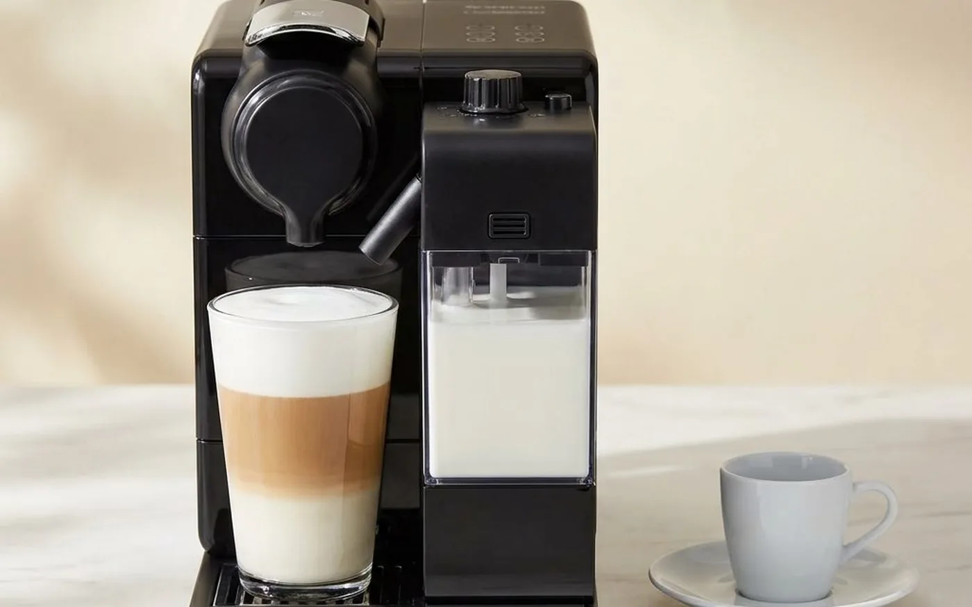 Nespresso Gran Lattissima dispensing steamed milk into a latte glass showing the LatteCrema milk system