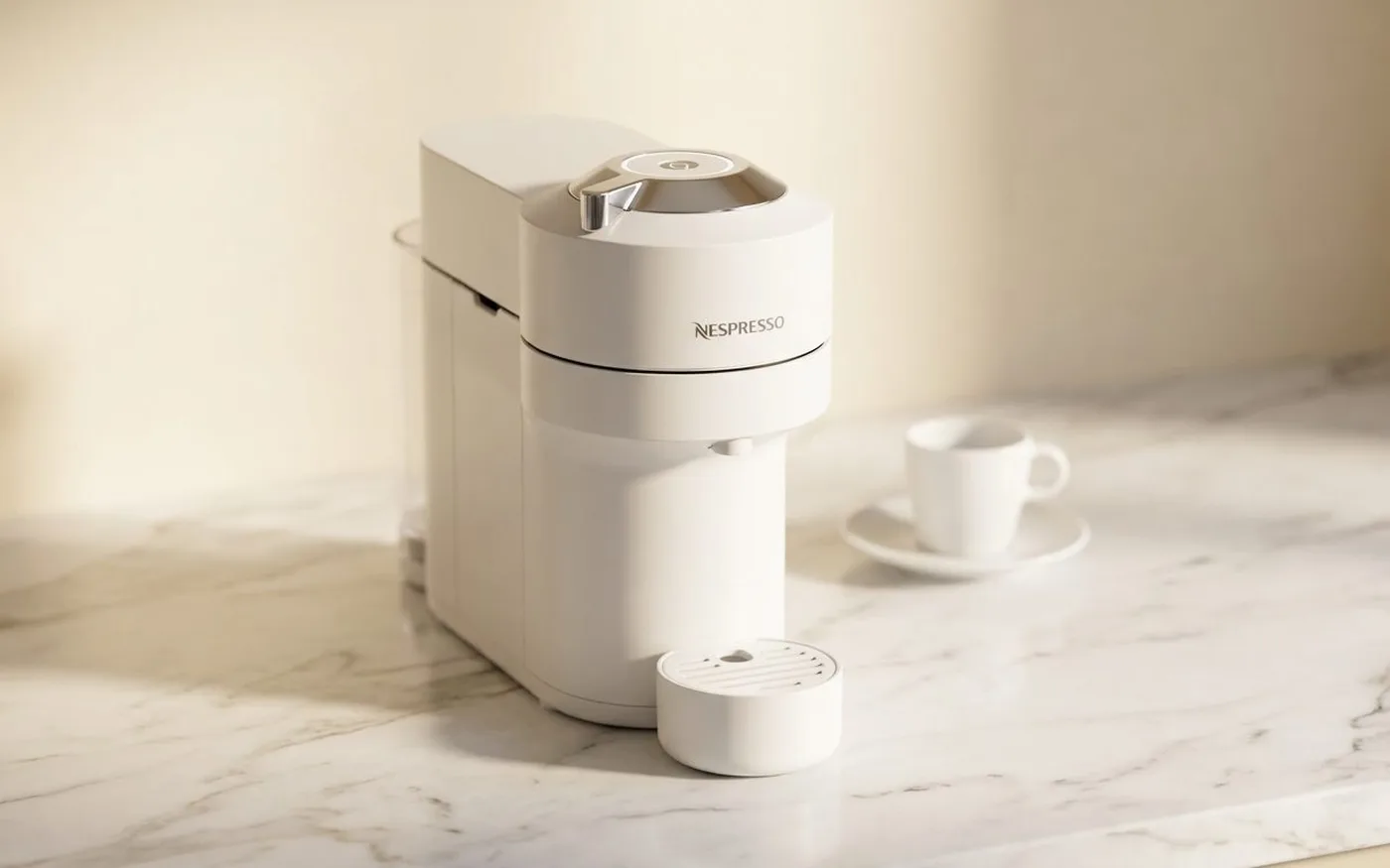 Nespresso Vertuo Next coffee pod machine in white on a white marble countertop