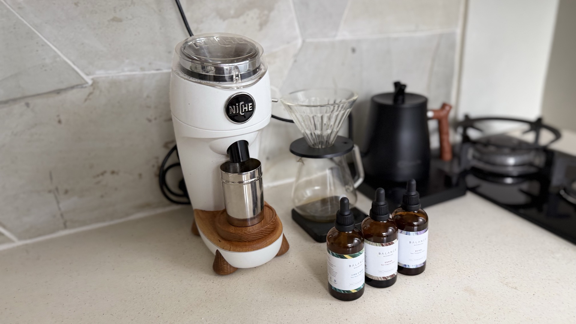 Niche Zero single-dose espresso grinder on a kitchen counter with grounds cup