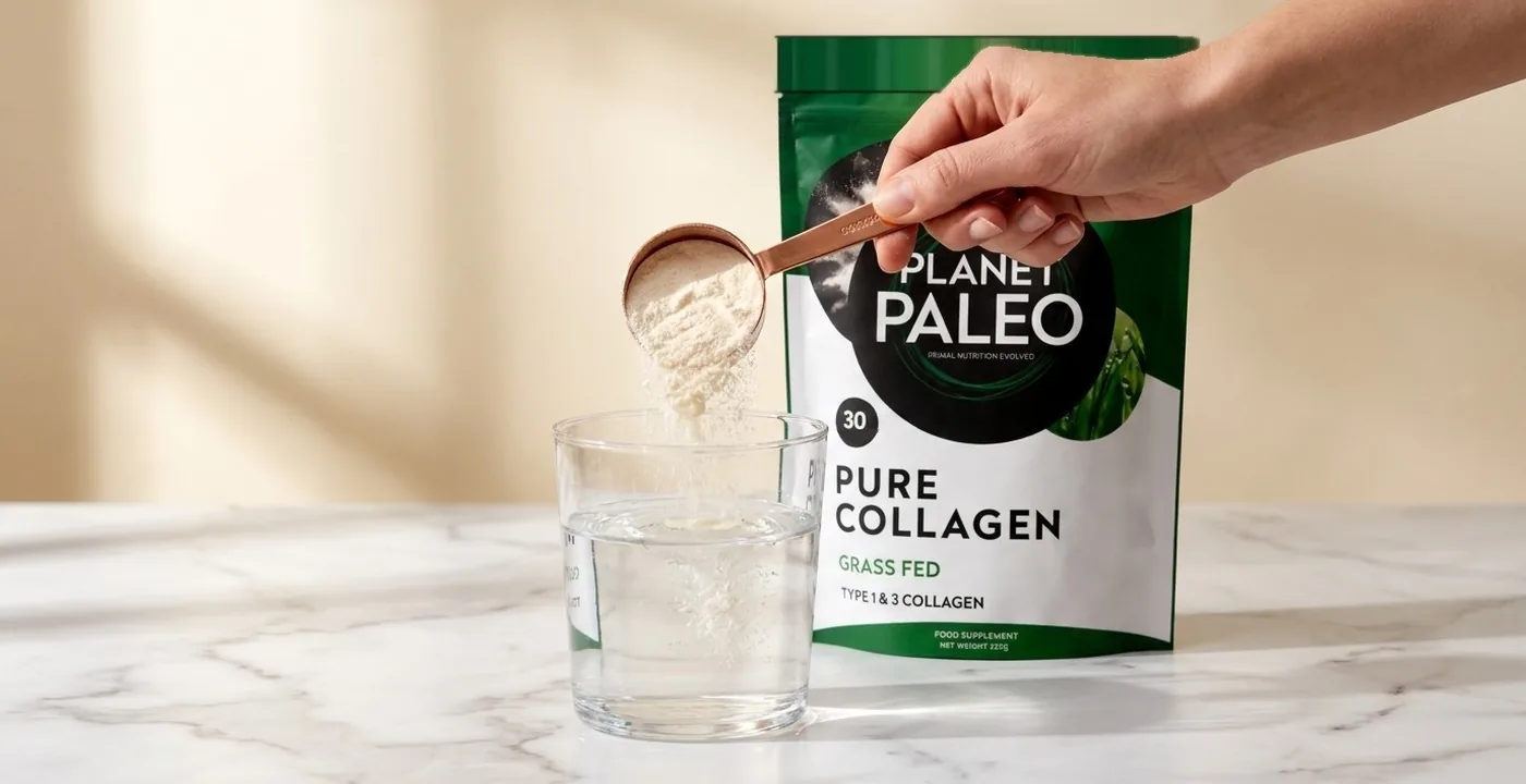 Planet Paleo Pure Collagen powder in a clear glass on a wooden surface