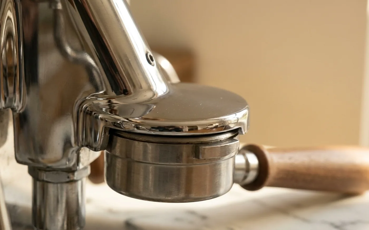 Close-up of the E61 group head and portafilter basket on the Rocket R58, chrome stainless steel build