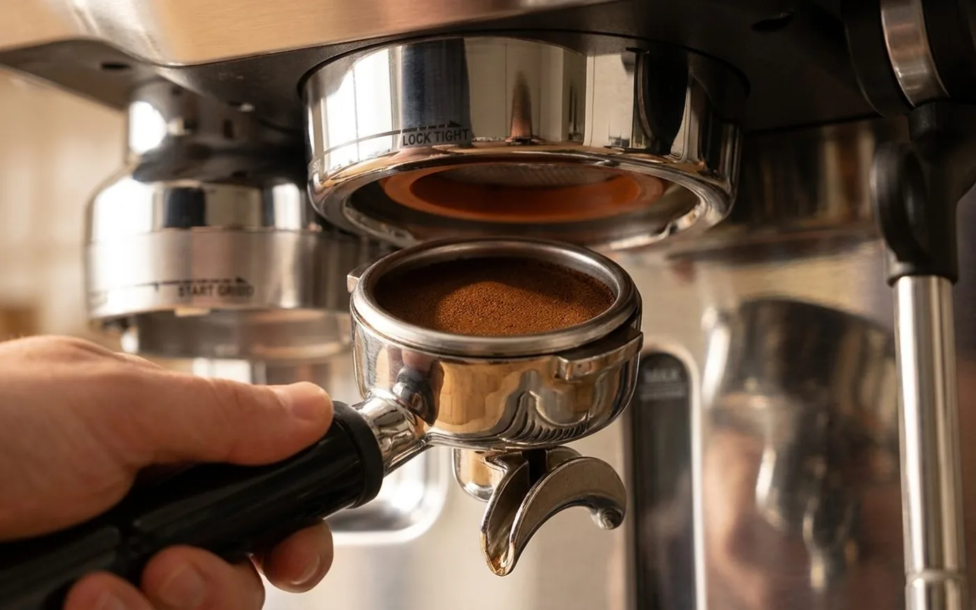 Sage Oracle Touch portafilter with tamped coffee puck being loaded into the group head for extraction