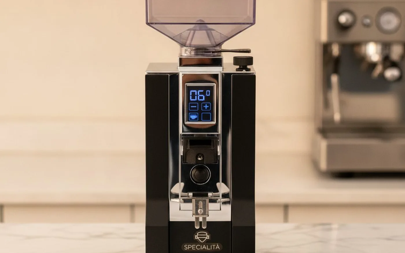 Eureka Mignon Specialita coffee grinder on white marble with scattered coffee beans